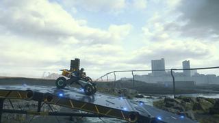 Un plan large montrant Sam traverser un pont à moto, avec un monorail suspendu plus loin, et de larges bâtiments en fond