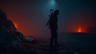 La silhouette de Deacon ressort dans une caverne illuminée de deux torches rouges, avec un agent NERO décédé au sol.