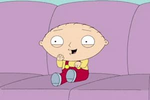 Stewie de Family Guy assis sur le canapé agitant mains et pieds plein d'excitation