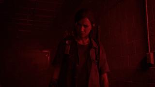 Ellie se tient, pensive, dans un couloir sombre, uniquement illuminé par une lumière d'alerte rouge.