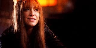 La “fausse” Olivia du monde alternatif dans la série Fringe hoche la tête et sourit.