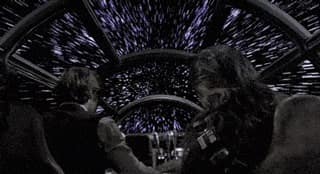 Han Solo et Chewbacca dans le Faucon Millenium qui passe à la vitesse de la lumière. On peut voir les points lumineux s'étendre en traits avant que le plan de change sur une vue statique du vaisseau entier qui diminue dans l'espace tandis qu'il s'éloigne.