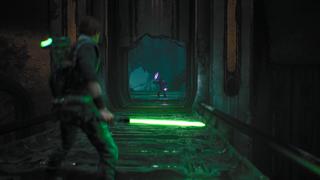 Cal est au premier plan dans un couloir, tenant son sabre laser à lumière verte ici. Au bout; un ennemi avec une sorte de massue électrifiée violette l'attend pour se battre.