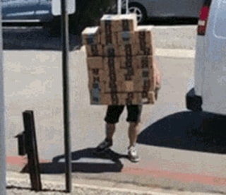 Un livreur soulève une vingtaine de colis en une seule fois.